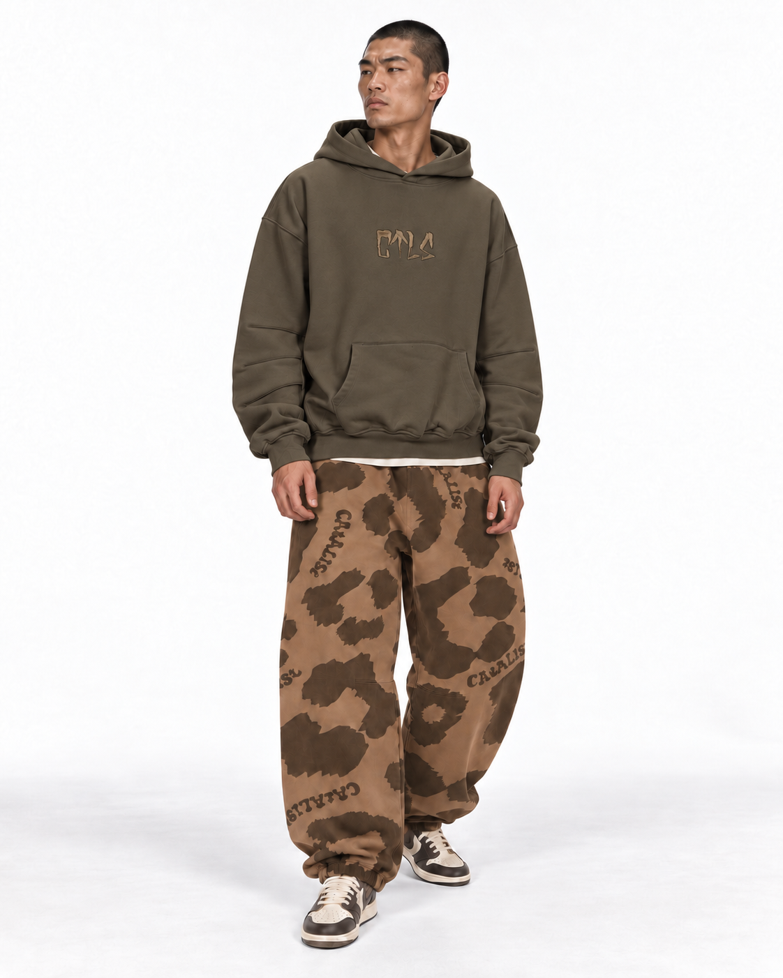Usual Hoodie ’25 BROWNとレオパードスウェットのスタイリング。白背景、坊主モデルの全身。